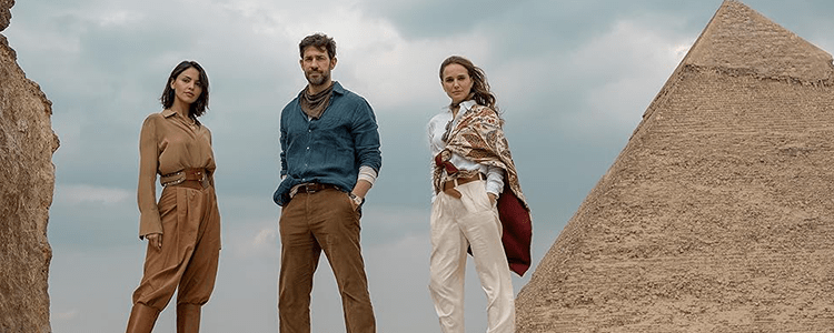 Three people posing right in front of an egyptian pyramid